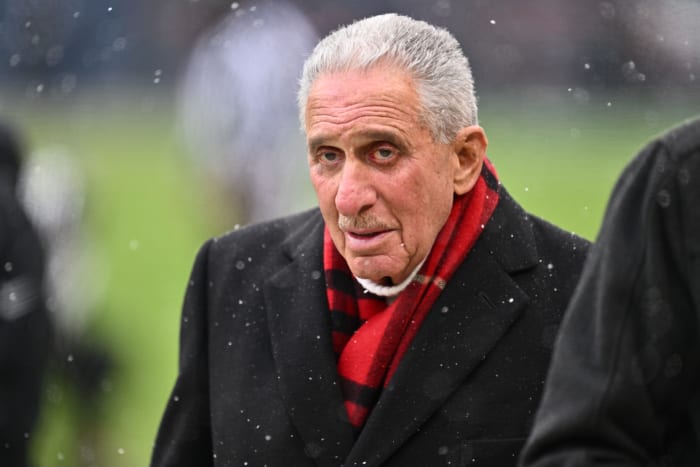 Arthur Blank wears a scarf amid snow on the field